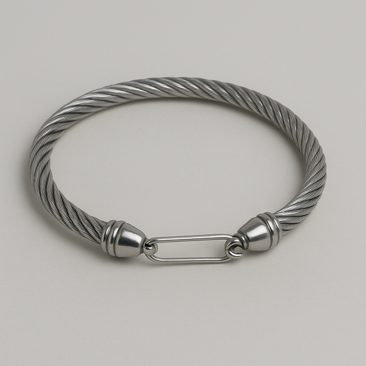 Stylish metallic bracelet with twisted design and secure clasp on a neutral background.